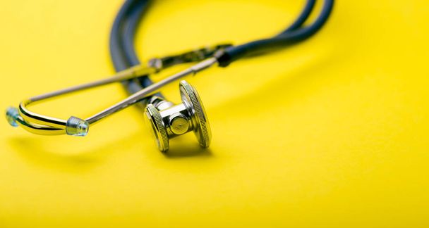 Selective focus of blue stethoscope on yellow background. For check heart or health check up concept. Copy space. - Fotoğraf, Görsel