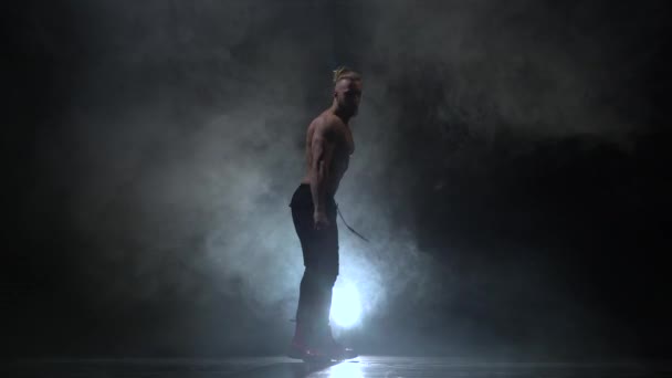 Jongen danst sexy dans opgepompt. Zwarte rook achtergrond - Video