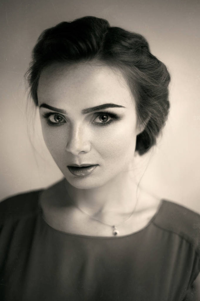 Mooie jonge vrouw met lichte make-up en kapsel, retro-stijl. Zwart-wit, sepia - Foto, afbeelding