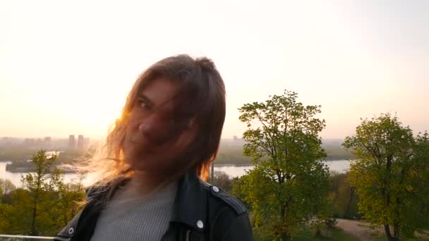 Όμορφο κορίτσι ισιώσει τα μαλλιά για την Ανατολή του ηλίου σε μια μεγάλη πόλη - Πλάνα, βίντεο