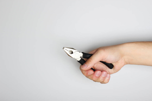 black pliers in hand on a light background - Foto, immagini