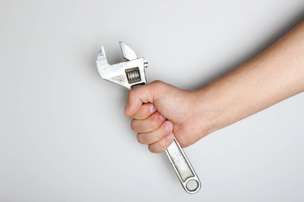 Schraubenschlüssel in der Hand auf hellem Hintergrund - Foto, Bild