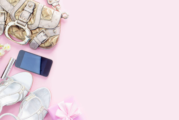 Сучасні модні аксесуари молоді жінки взуття сумка телефон гаджет подарункова коробка рожевий фон. Вид зверху плоский лежав
 - Фото, зображення