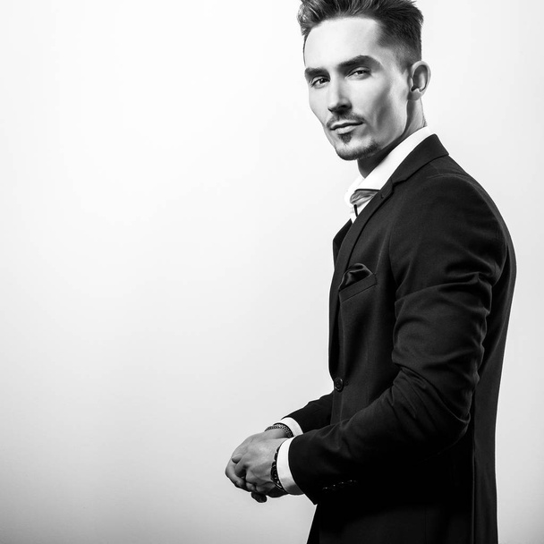Handsome young elegant man in black stylish classic costume. Black-white photo. - Photo, Image