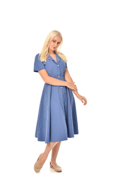 full length portrait of blonde girl wearing blue dress. standing pose. isolated on white  studio background. - Fotó, kép