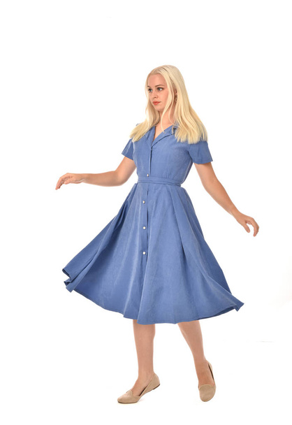 full length portrait of blonde girl wearing blue dress. standing pose. isolated on white  studio background. - Фото, изображение