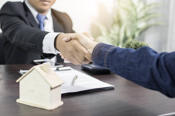 Успешное соглашение, недвижимость, концепция договора купли-продажи дома, покупатель пожимает руку банковским служащим после окончания подписания договора в офисе - Фото, изображение