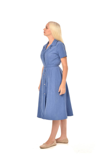 full length portrait of blonde girl wearing blue dress. standing pose. isolated on white  studio background. - Фото, зображення