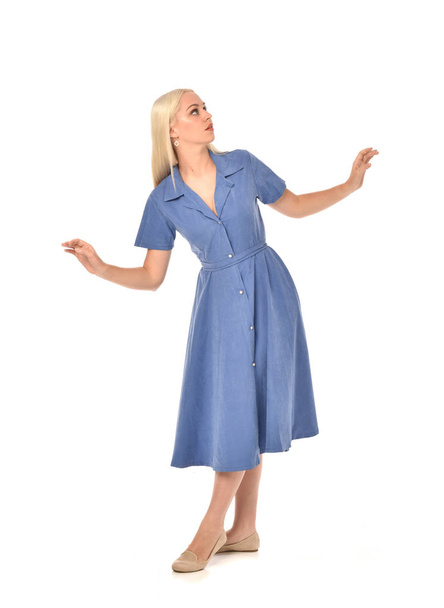 Ganzkörperporträt eines blonden Mädchens mit blauem Kleid. Stehende Pose. isoliert auf weißem Studiohintergrund. - Foto, Bild