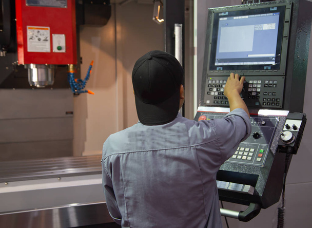 Industriearbeiter geben Datenprogrammierung für CNC-Fräsmaschine ein - Foto, Bild