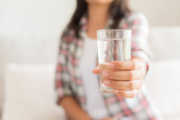 Happy beautiful young woman holding drinking water glass in her hand. Health care concept. - Foto, Imagem