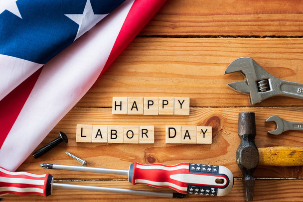 USA Labor day concept, First Monday in September. Different kinds on wrenches, handy tools, America flag and wooden blocks on wooden table. - Foto, imagen