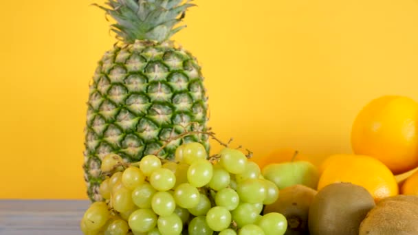 Egészséges és bio egzotikus gyümölcsök sárga háttér - Felvétel, videó