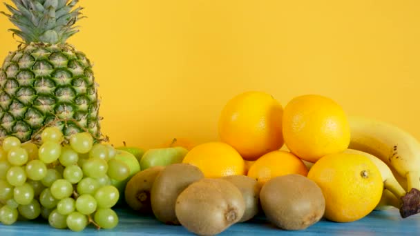 Variety mix of exotic fruits on yellow background - Footage, Video