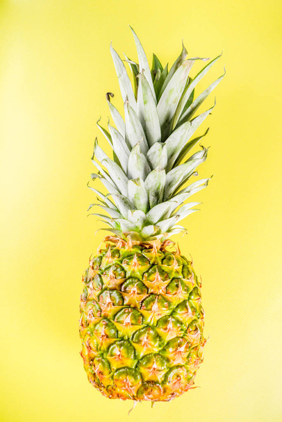 Fresh whole pineapple on bright blue yellow background copy space - Foto, afbeelding