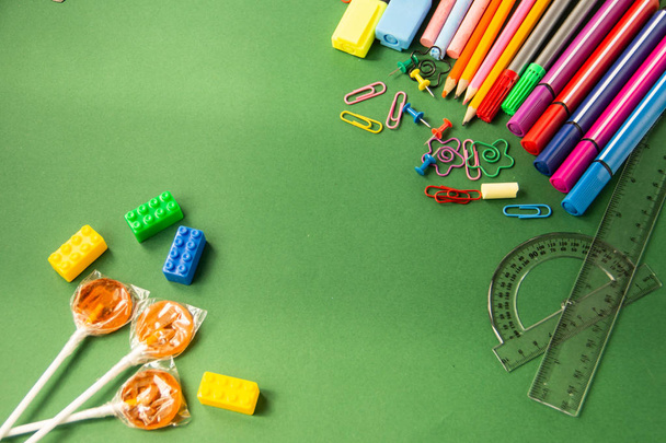 Поясні ручки, олівці, олівці, лінійки на зеленому тлі
 - Фото, зображення