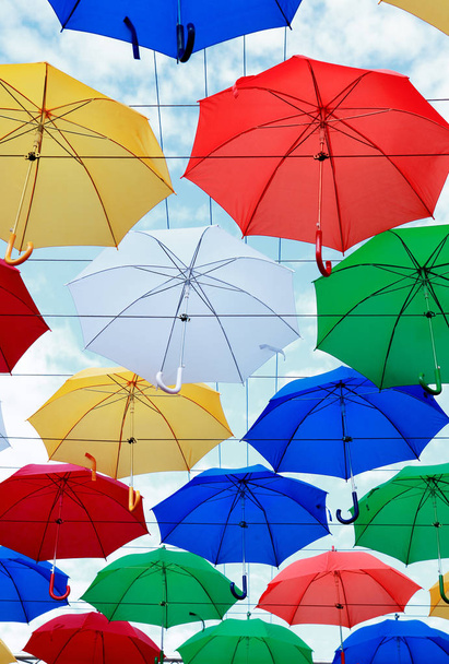 Mnoho rozmanitosti barevné deštníky jako pozadí proti modré obloze - Fotografie, Obrázek