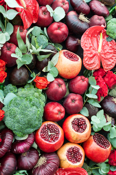 rote und grüne Stillleben von reifen Früchten Granatapfel, Apfel, Blumenkohl und schönen Rosen als Dekoration. - Foto, Bild