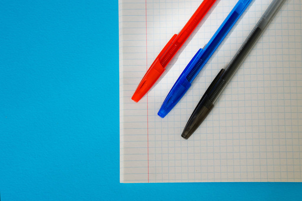 Tiempo para negocios y estudio. Plumas estilográficas azules, rojas y negras se encuentran en el cuaderno de matemáticas
.                               - Foto, imagen