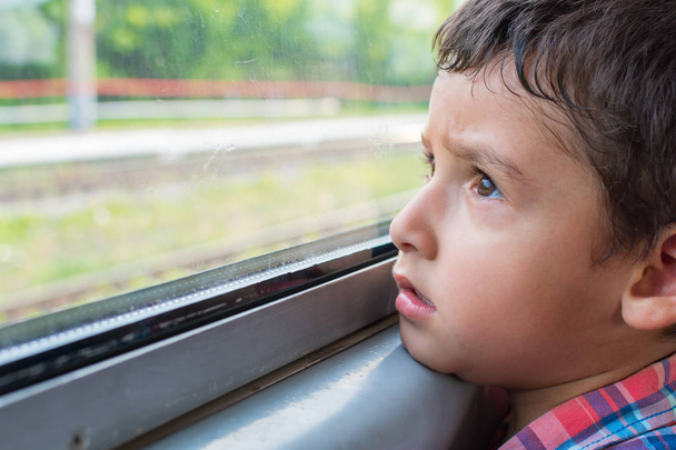 Üzgün çocuk bir tren sürmek ve pencereden görünüyor - Fotoğraf, Görsel