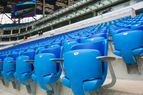 Tribuna de fans en el estadio. Asientos azules vacíos en el estadio
 - Foto, Imagen
