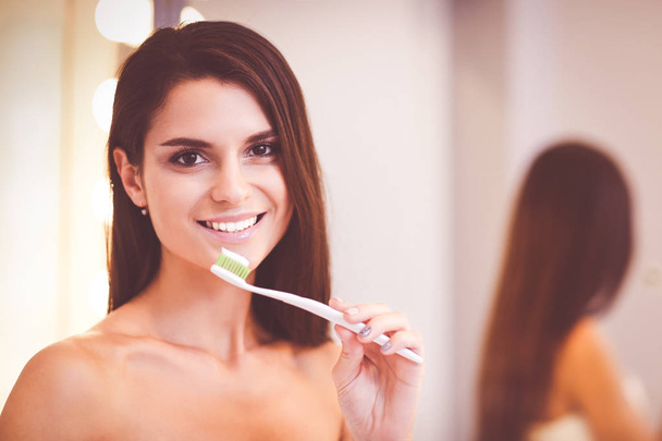 Portrait of a young girl cleaning her teeth. - Фото, зображення