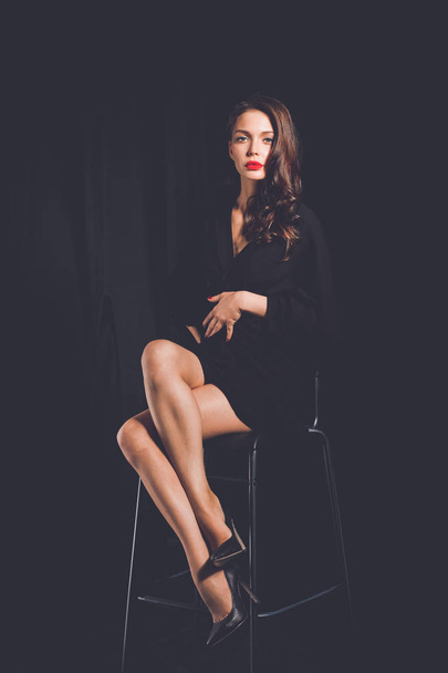 Beautiful woman sitting a chair, isolated on lack background. Beautiful woman. - Fotografie, Obrázek