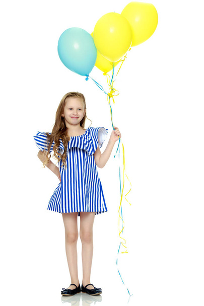 Adorable little blond girl in very short summer striped dress. - Photo, image