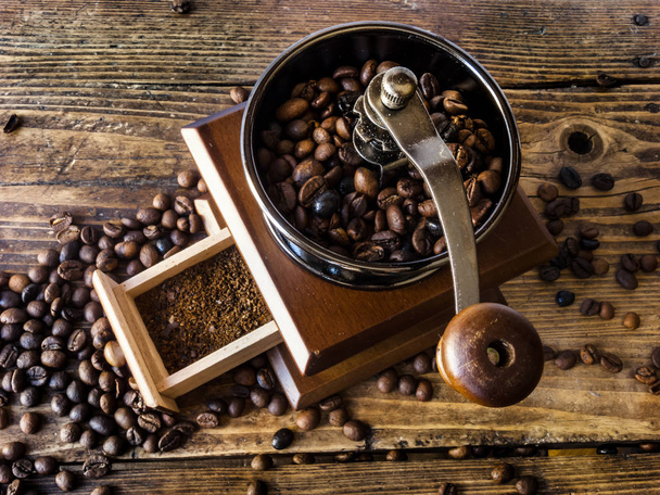 Molinillo de café de madera con café molido, sobre un fondo de madera
 - Foto, Imagen