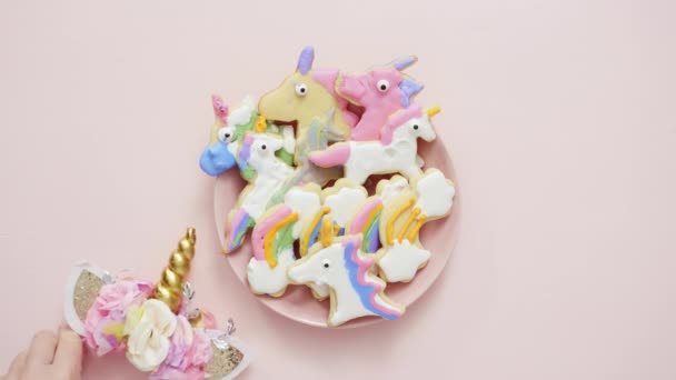Unicorn shaped sugar cookies decorated with royal icing on pink plate - Footage, Video