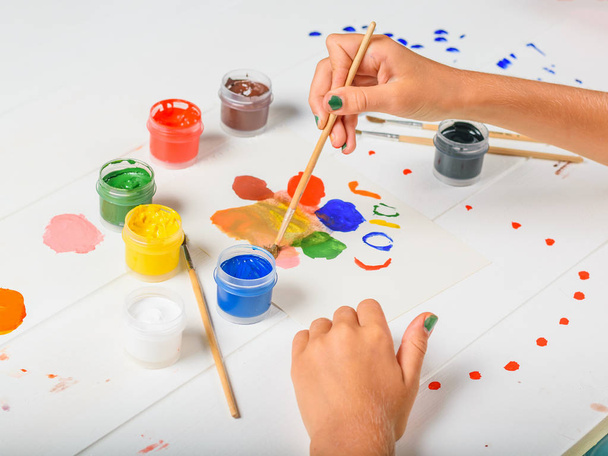 L'enfant sélectionne la couleur souhaitée sur une table en bois blanc. Kit créatif. Hobby et style
. - Photo, image