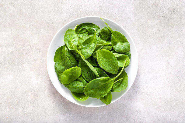 Fresh spinach. Green vegetable leaves on plate, healthy food, vegetarian diet concept. - Fotografie, Obrázek