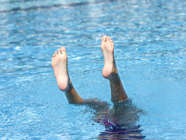 Pie de una chica zambulléndose en el agua, saliendo de la piscina
 - Foto, Imagen