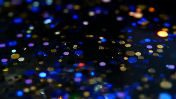 Confetti glitter multicolore sfocati e luccicanti, sfondo nero. Vacanze astratto festivo bokeh punti luce
. - Filmati, video