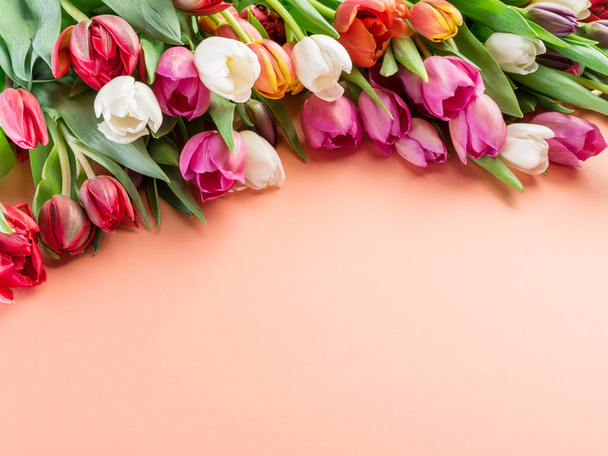 Colorful  bouquet of tulips on orange background.  Top view. - Photo, Image
