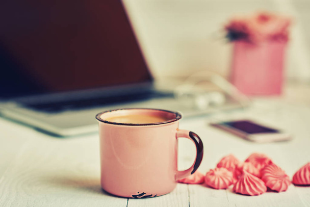 Feminine workplace. Closeup cup hot chocolate, worksplace with laptop and flowers on the background. Cozy work space on old wooden table. Creative planning concept.  Vintage style. Selective focus. - Foto, Bild