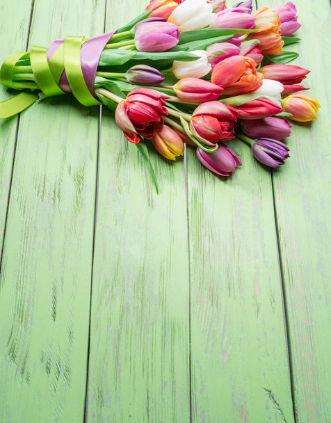 Colorful  bouquet of tulips on green wooden background. Top view. - Foto, afbeelding