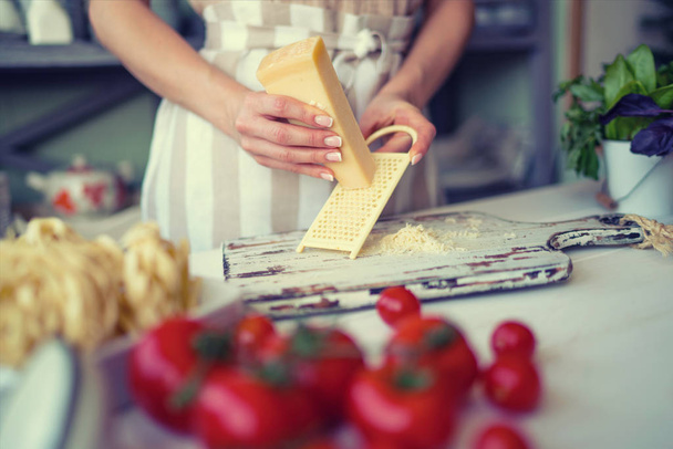 Close up of unrecognizable cook,cutting tomatoes and other vegetables with knife while working in home kitchen. Woman cooking salad, bio food preparing.  - Fotoğraf, Görsel