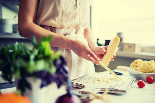 Lähikuva tunnistamaton kokki, leikkaus tomaatit ja muut vihannekset veitsellä työskennellessään kotona keittiössä. Nainen ruoanlaitto salaatti, bio elintarvikkeiden valmistus
.  - Valokuva, kuva