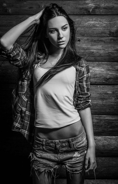 Attractive women portrait against wooden background. Black-white photo. - Fotografie, Obrázek