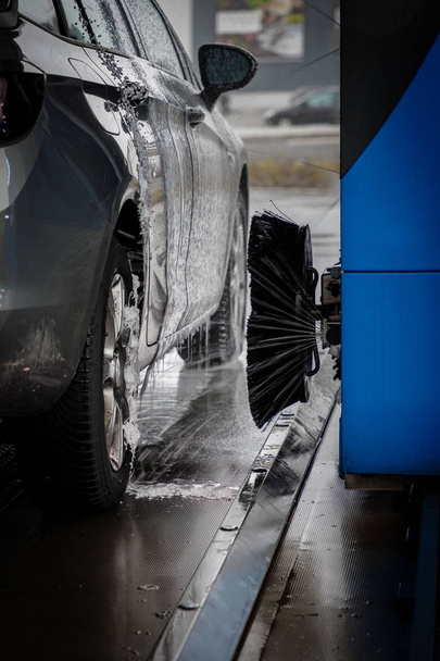 Pneumatici per auto vengono lavati in un autolavaggio
. - Foto, immagini