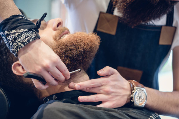 Primo piano della mano di un barbiere con le forbici durante la rifilatura
 - Foto, immagini