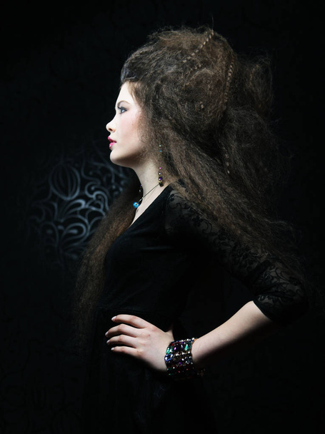 portrait of beautiful woman in black dress with fashion hairstyle. Fashion and beauty concept. - 写真・画像