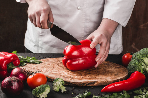 Шеф-повар режет овощи ножом на кухне, готовит еду. Ингредиенты на столе. Концепция здорового питания. Вид сверху
 - Фото, изображение