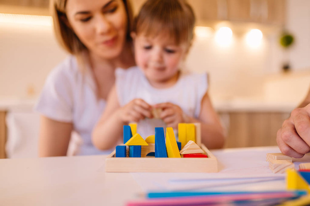 Portrait of mother and her daughter who are playing with toys. Blurred image. - 写真・画像