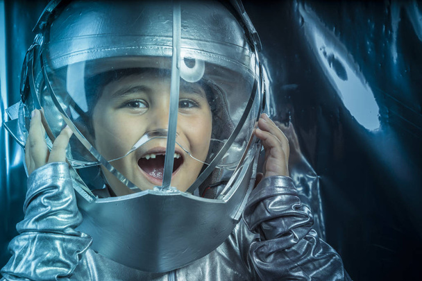 Game, Boy playing to be an astronaut with space helmet and metal suit - Fotoğraf, Görsel