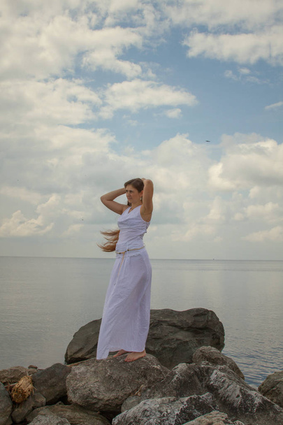 beautiful girl with long hair and white dress by the sea - Foto, Bild