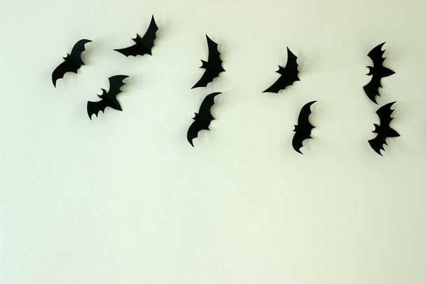 eine mit Fledermäusen aus Pappe verzierte Wand. Halloween-Konzept, selektiver Fokus. - Foto, Bild