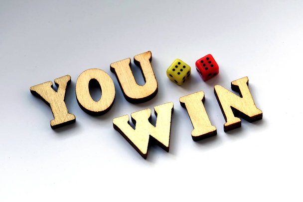 Wooden letters and dice on a white background. You win. - Photo, Image
