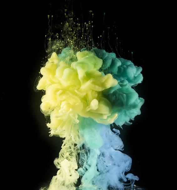 Colorful rainbow paint drops from above mixing in water. Ink swirling underwater. - Φωτογραφία, εικόνα
